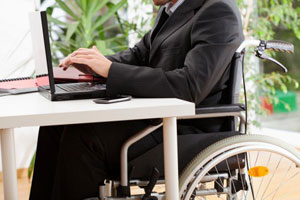 Man in a wheelchair working on a computer